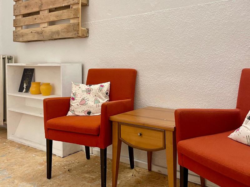 two red lounge chairs next to a white sideboard