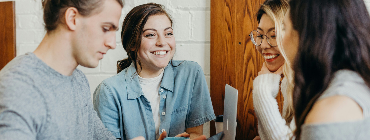 Group of smiling young people talking to each other