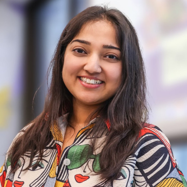 Young woman in colourful shirt smiling at camera